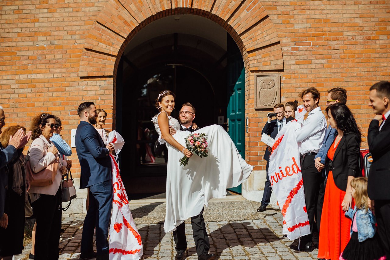 Der Bräutigam trägt die Braut auf dem Arm vor dem Alten Rathaus in Ingolstadt 