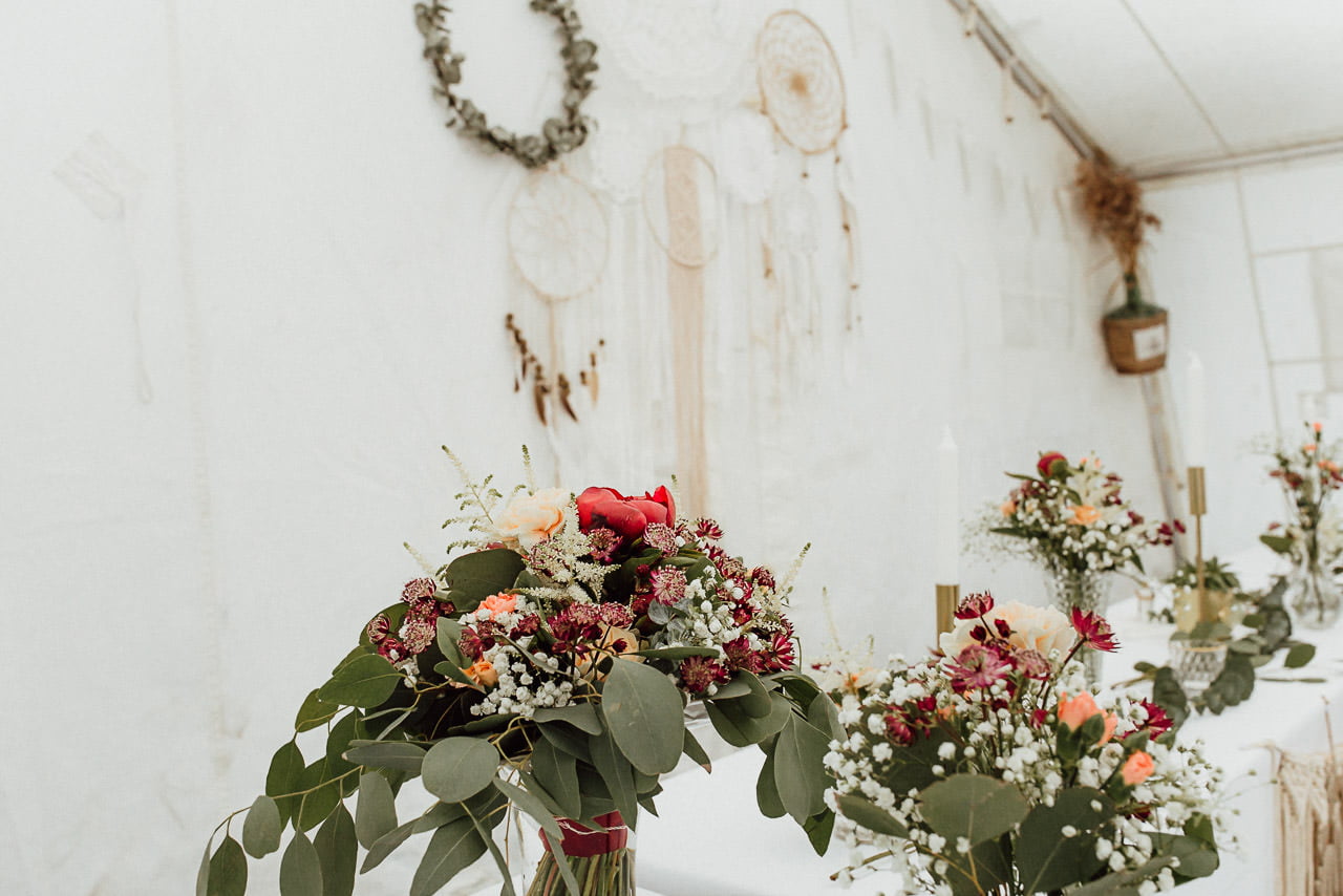 Innendekoration für eine Hochzeit im Boho-Stil, Makramee und Blumensträuße