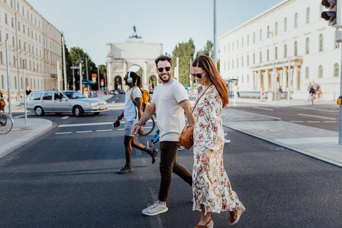 Pärchen Bilder | Ideen für süße Pärchenfotos in München 23 Ein Paar während eines Photoshootings in München überquert eine Straße in der Nähe des Siegestors
