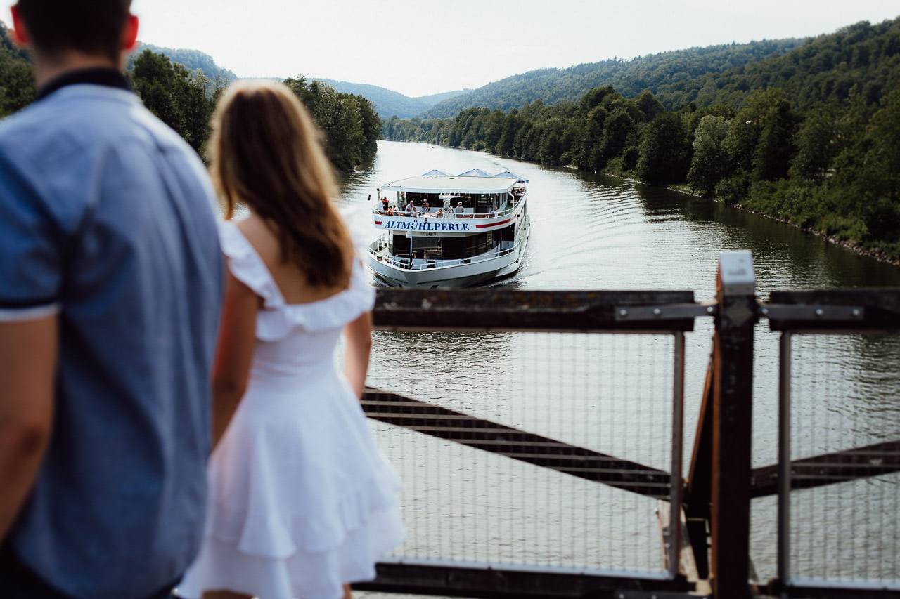 Bilder von Paaren auf der Holzbrücke Tatzlwurm in Essing. Schiff auf dem Fluss.