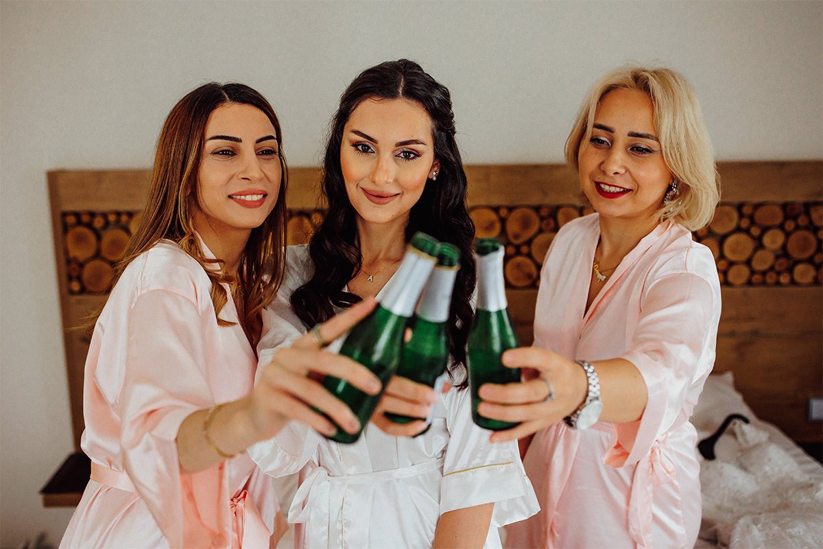 Braut und Brautjungfern und Flaschen Champagner