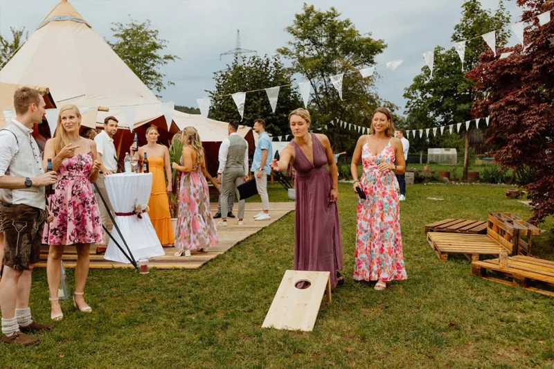 Elegante Frauen in Zelten bei einer Hochzeitsfeier, beide tragen bodenlange Kleider gemäß dem Dresscode Hochzeitsgast.