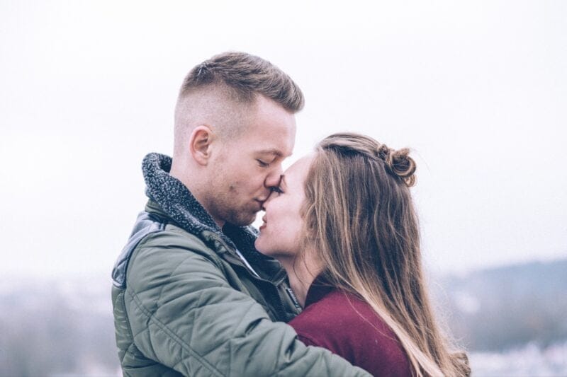 Ein Porträt eines Paares vor einer Bergkulisse, der Mann küsst die Frau liebevoll auf die Nase, um den 11. Hochzeitstag zu feiern.
