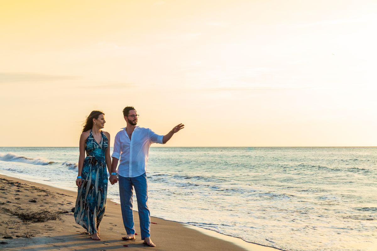 16. Hochzeitstag - Saphirhochzeit. Bedeutung und Geschenkideen. 4 Glückliche Perlmutthochzeit - Ein Paar schlendert am Strand entlang, während die Sonne untergeht, und feiert seine 30-jährige Ehe.
