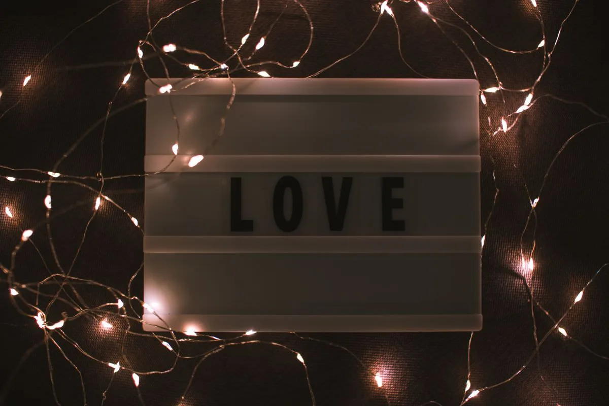 Eine romantische Tafel mit dem Schriftzug "Liebe" und funkelnden LED-Lichtern, die die festliche Stimmung der Amberhochzeit unterstreicht.