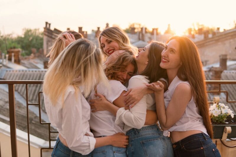 Frauen umarmen die zukünftige Braut während einer JGA-Ideenveranstaltung für Frauen.