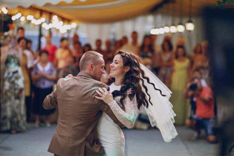 Eine glückliche Braut und Bräutigam tanzen auf ihrer Hochzeit zu den mitreißenden Klängen von Gänsehaut Lieder Hochzeit.