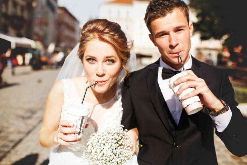 Ein Paar genießt nach seiner Hochzeit zu zweit einen Kaffee in der Stadt während eines Spaziergangs.