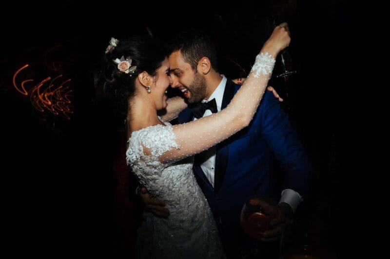 Ein Brautpaar tanzt während ihres Hochzeitstanzes mit Champagnergläsern in den Händen.