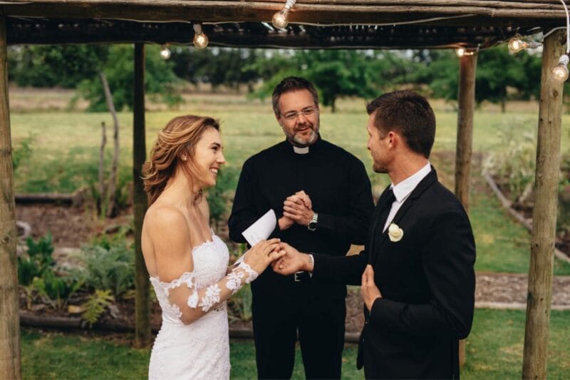 Brautpaar während ihrer Hochzeitszeremonie mit dem Priester, der die Lesung Hochzeit durchführt.