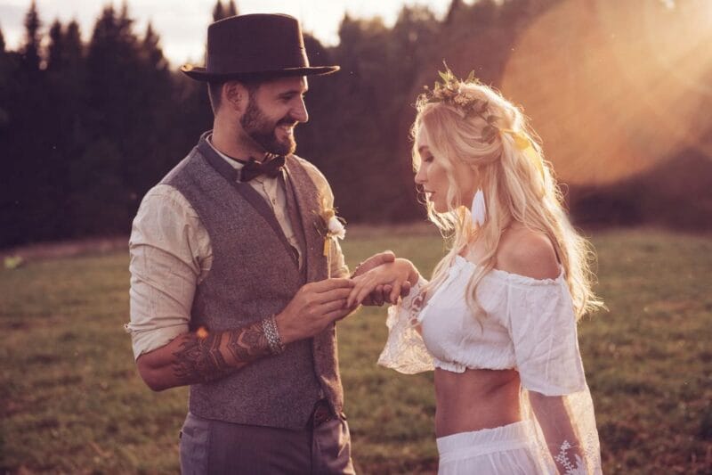 Romantisches Brautkleid Zweiteiler einer Braut und eines Bräutigams bei Sonnenuntergang.