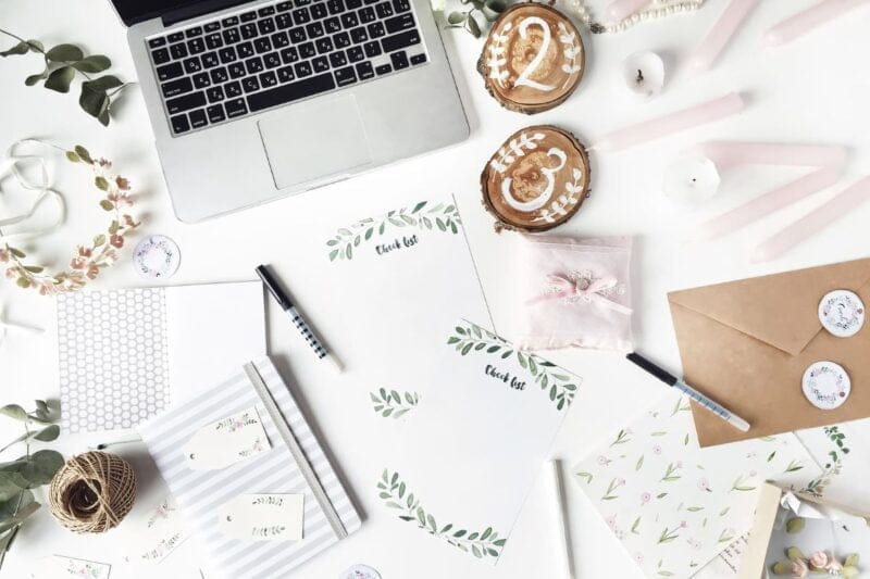 Utensilien zur Erstellung eines Hochzeitseinladung Spruchs - Laptop, Papier und Umschlag.