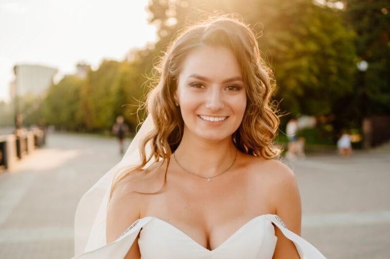 Eine Braut mit lockigen offenen Haaren Hochzeit bei Sonnenuntergang.