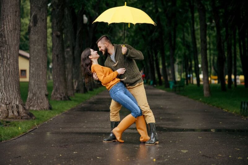 Regenschirmtanz hochzeit: Ein Mann und eine Frau tanzen unter einem Regenschirm.