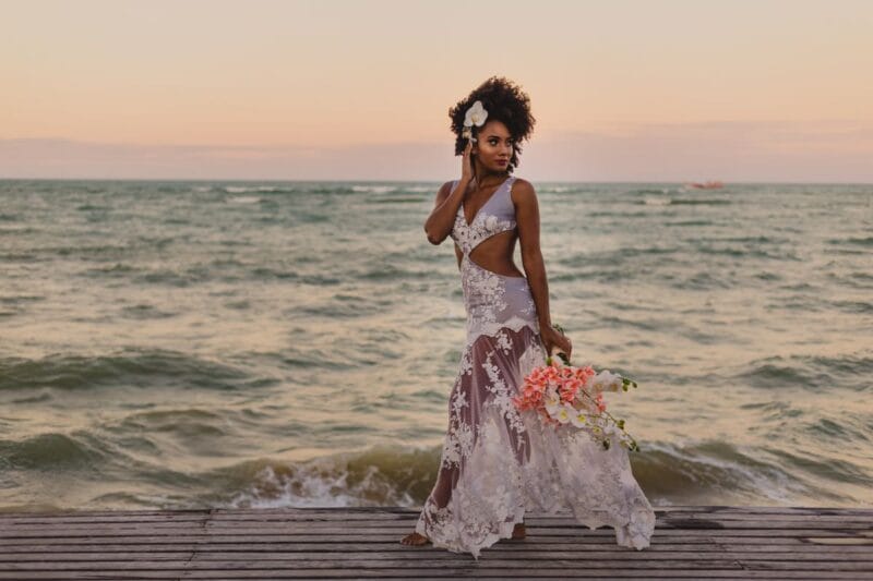 Eine Brautfrisur mit Blumenkranz verleiht der Braut einen natürlichen und romantischen Look, perfekt für eine Strandhochzeit.