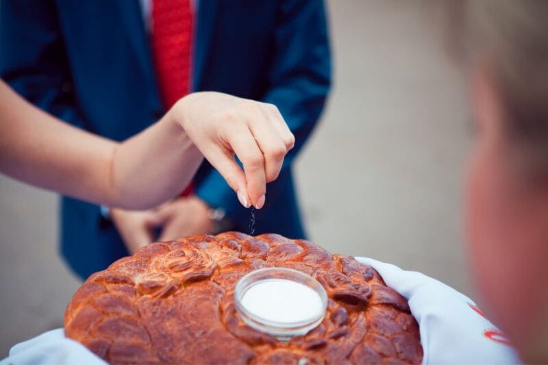 Ein frisch verheiratetes Paar tauscht Brot und Salz Hochzeit als traditionelles Symbol für Wohlstand und Glück während ihrer Hochzeitsfeier aus.