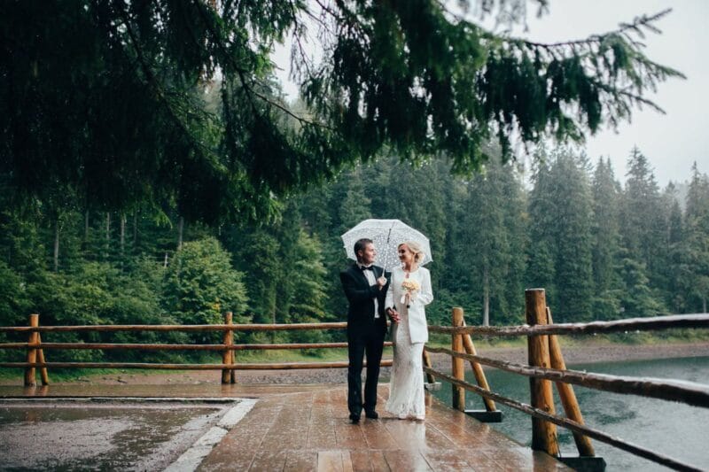 Ein Brautpaar, das während einer Hochzeit im Regen steht.