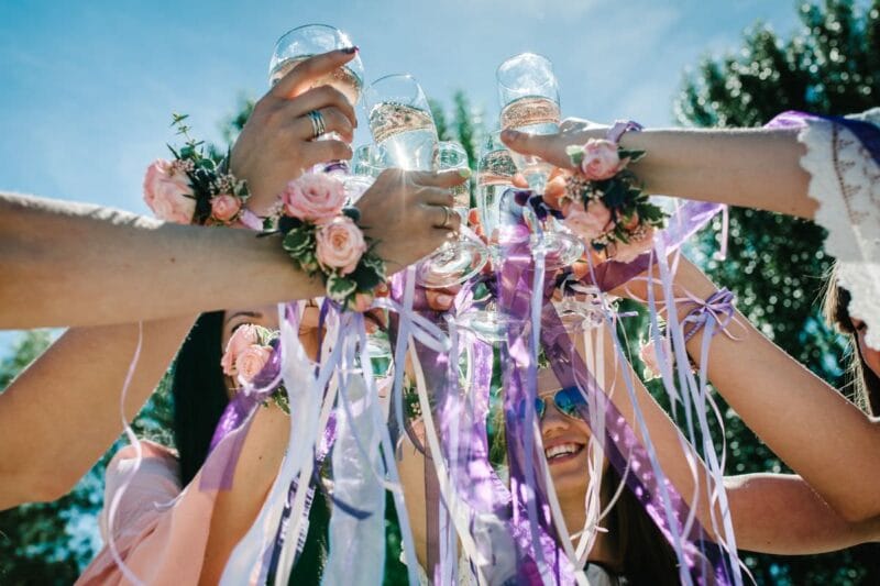 Brautjungfern stoßen beim Sektempfang zur Hochzeit mit Sektgläsern an.