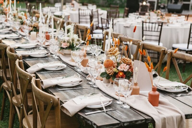 Eleganter Tisch mit außergewöhnlichen Tischkarten und Blumendekorationen bei einer Gartenhochzeit.