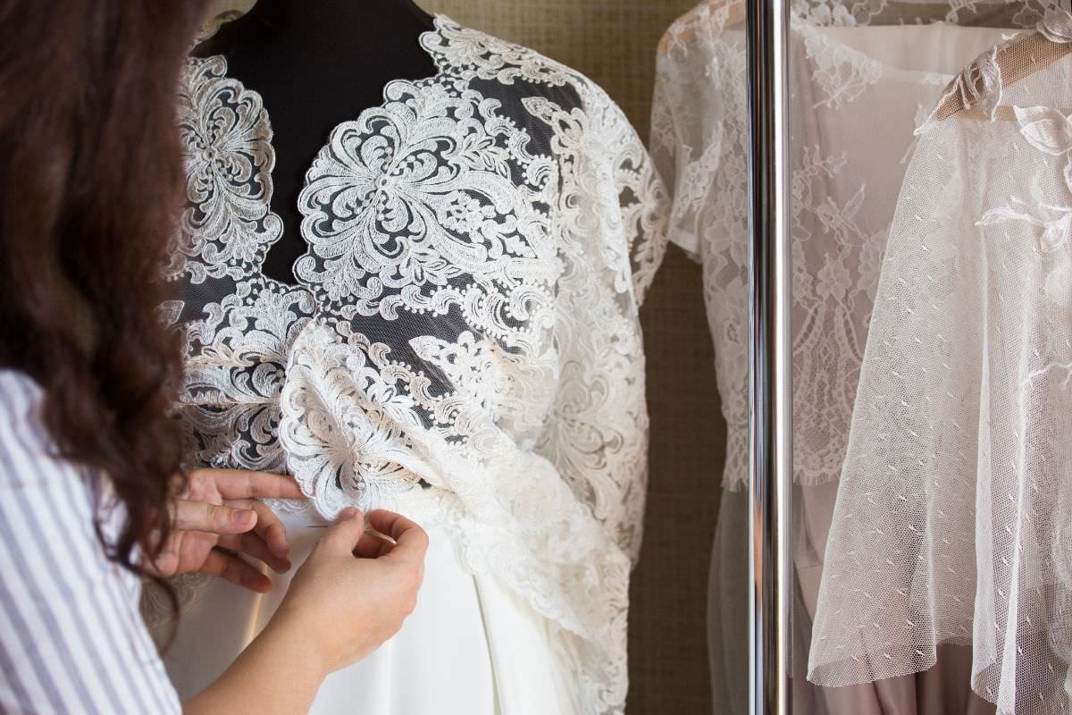 Detailansicht eines Brautkleides mit filigraner Tattoo Spitze, sorgfältig angepasst auf einer Schneiderpuppe.