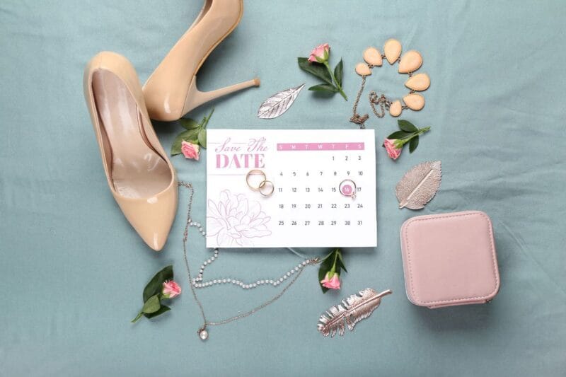 Brautschuhe, Hochzeitsaccessoires und Eheringe neben einem Hochzeitscountdown.