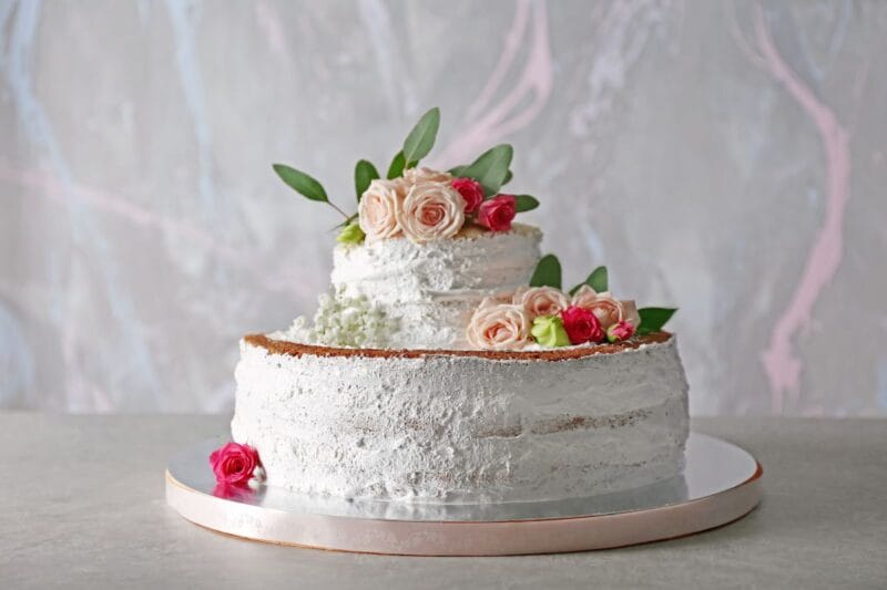 Rustikale Eistorte Hochzeit mit Rosen und grünem Blattwerk, teilweise ohne Zuckerguss.