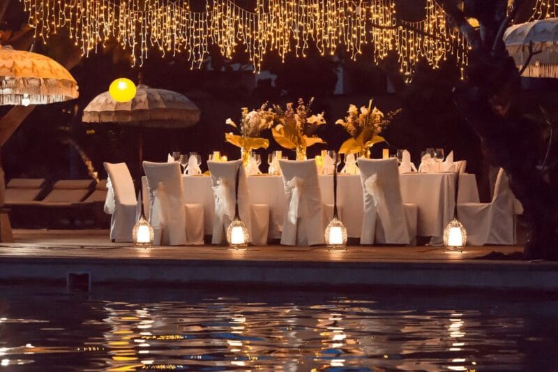 Romantisches Abendessen im Freien, dekoriert mit Lichtern und Blumen, perfekt für lustige Geschichten zur Hochzeit zum Vorlesen