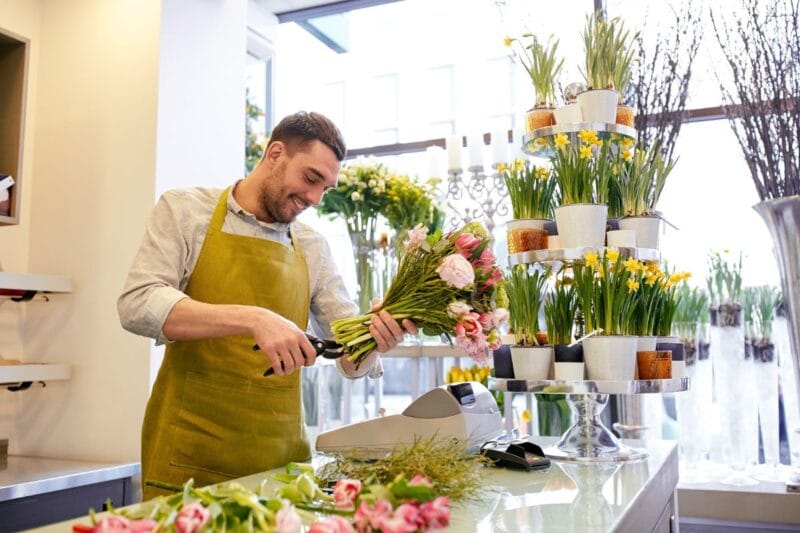Florist bei der Arbeit, der Blumenstrauß für eine Hochzeit arrangiert – Florist Hochzeit kosten.