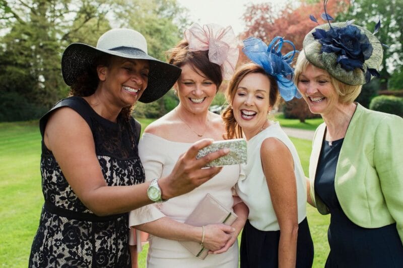 Hochzeit Gäste beschäftigen sich, indem sie gemeinsam ein Selfie machen und lachen.