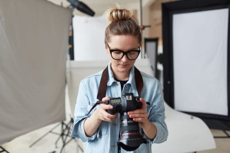 Fotografin überprüft Kameraeinstellungen – die beste Kamera für Anfänger.